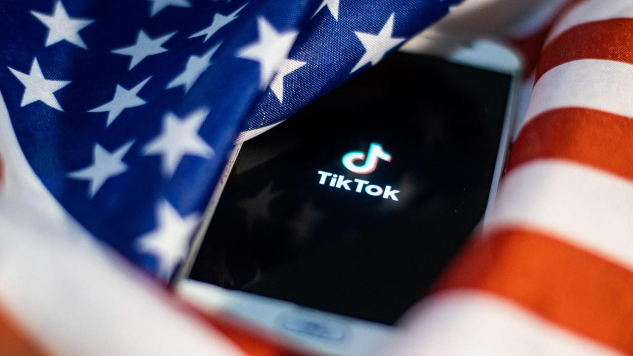 TikTok closeup logo displayed on a phone screen, smartphone on the American flag or U.S. flag, the national flag of the United States are seen in this multiple exposure illustration. Tik Tok is a Chinese video-sharing social networking service owned by a Beijing based internet technology company, ByteDance.  It is used to create short dance, lip-sync, comedy and talent videos. ByteDance launched TikTok app for iOS and Android in 2017 and earlier in September 2016 Douyin fror the market in China. TikTok became the most downloaded app in the US in October 2018. President of the USA Donald Trump is threatening and planning to ban the popular video sharing app TikTok from the US because of the security risk.  On August 3, 2020 in Thessaloniki, Greece.(Photo by Nicolas Economou/NurPhoto) | Keine Weitergabe an Wiederverkäufer.