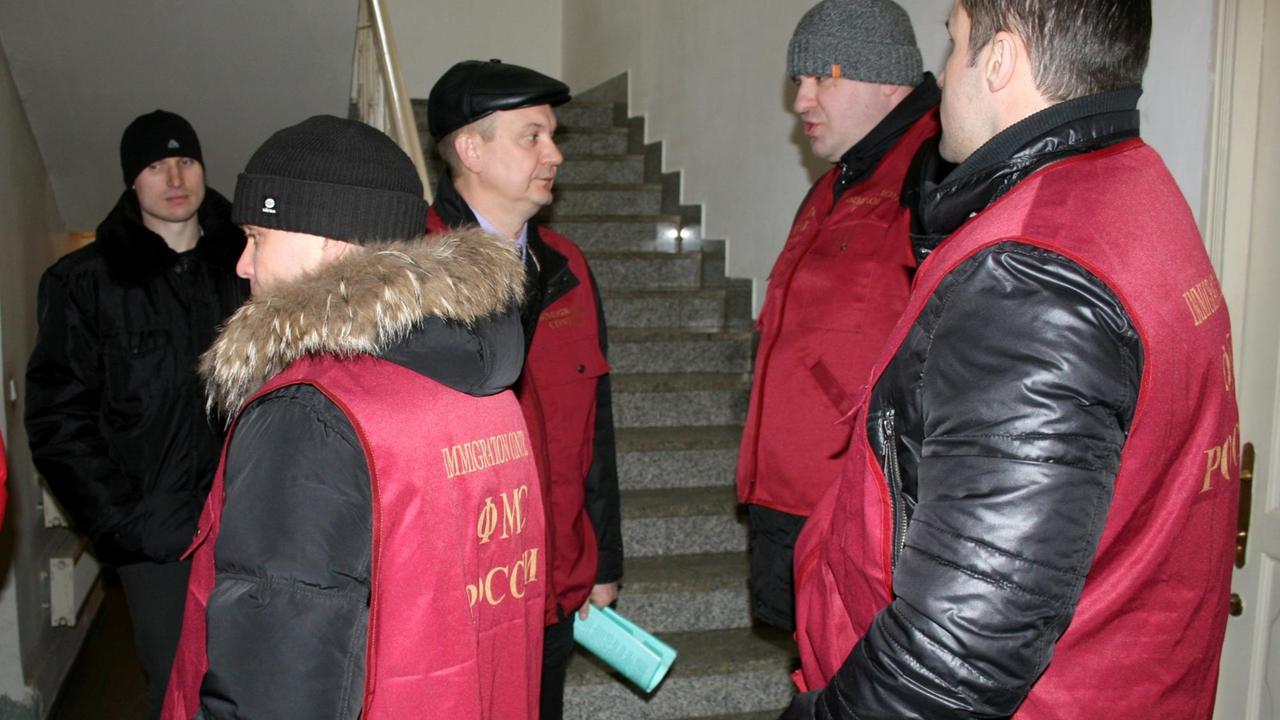 Mitarbeiter der Ausländerbehörde stehen im Sacharow-Zentrum in Moskau. Mit der Razzia unterbrachen russische Behörden die Gerichtsshow «Die Moskauer Prozesse» des Schweizer Regisseurs Milo Rau über Kunstfreiheit im größten Land der Erde. 