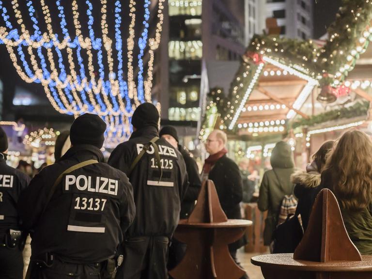 Polizisten laufen über den Weihnachtsmarkt am Berliner Breitscheidplatz.