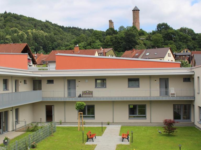 Das Seniorendorf Kirkel hat beige Wände und orangenen Dächer, im Zentrum der Gebäude sind Grünflächen.