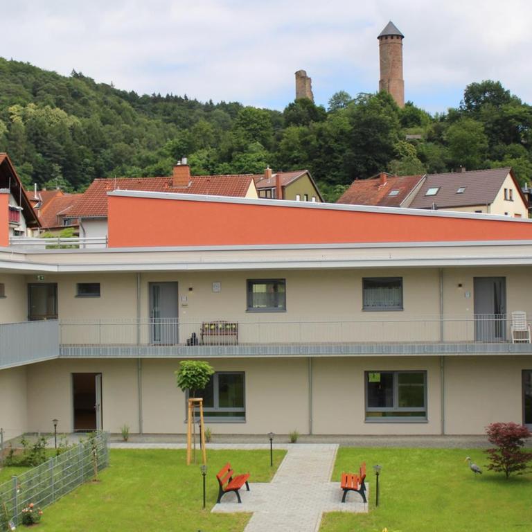 Das Seniorendorf Kirkel hat beige Wände und orangenen Dächer, im Zentrum der Gebäude sind Grünflächen.