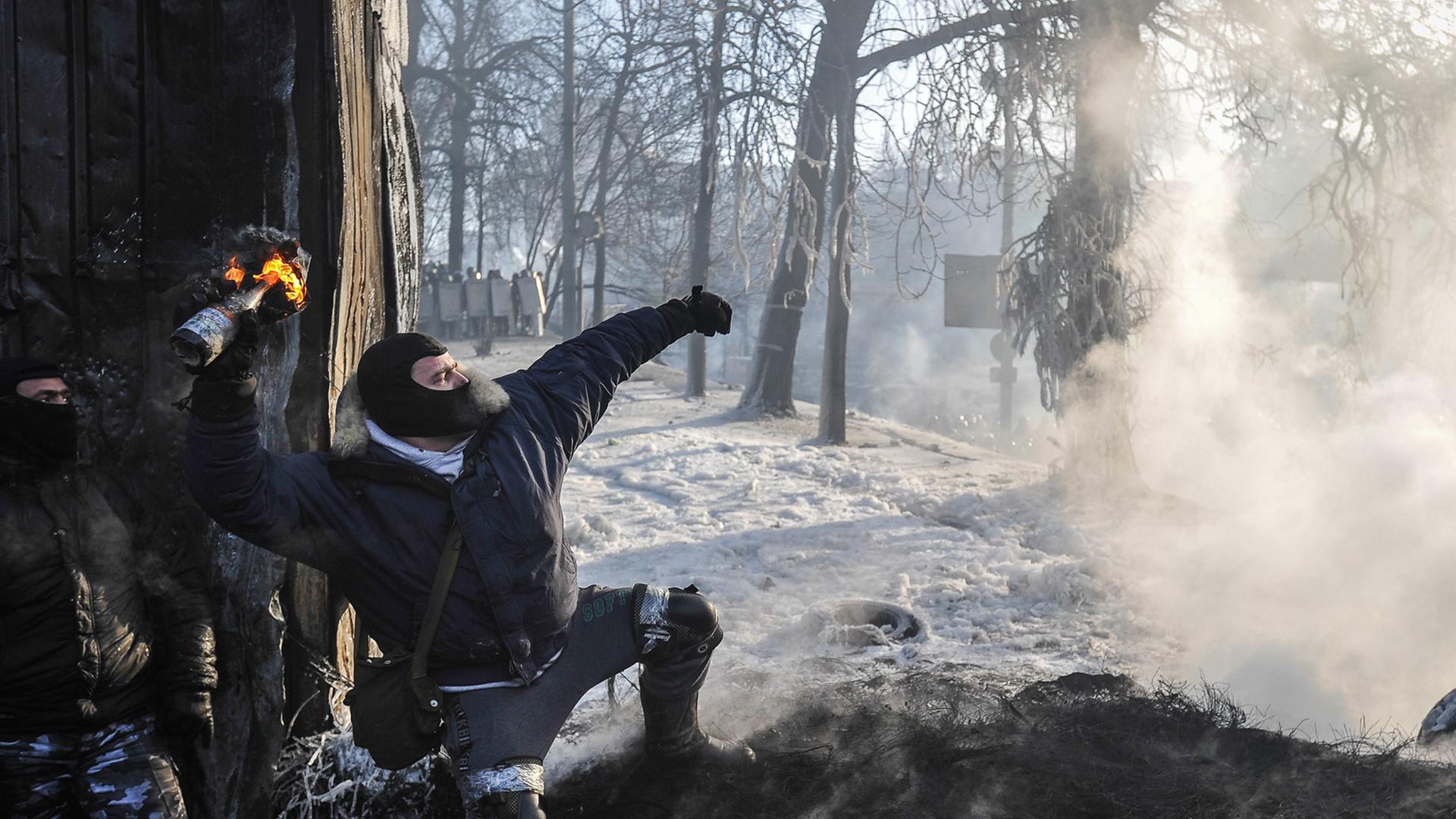 Andauernde Unruhe: Ein Demonstrant wirft einen Brandsatz in Kiew