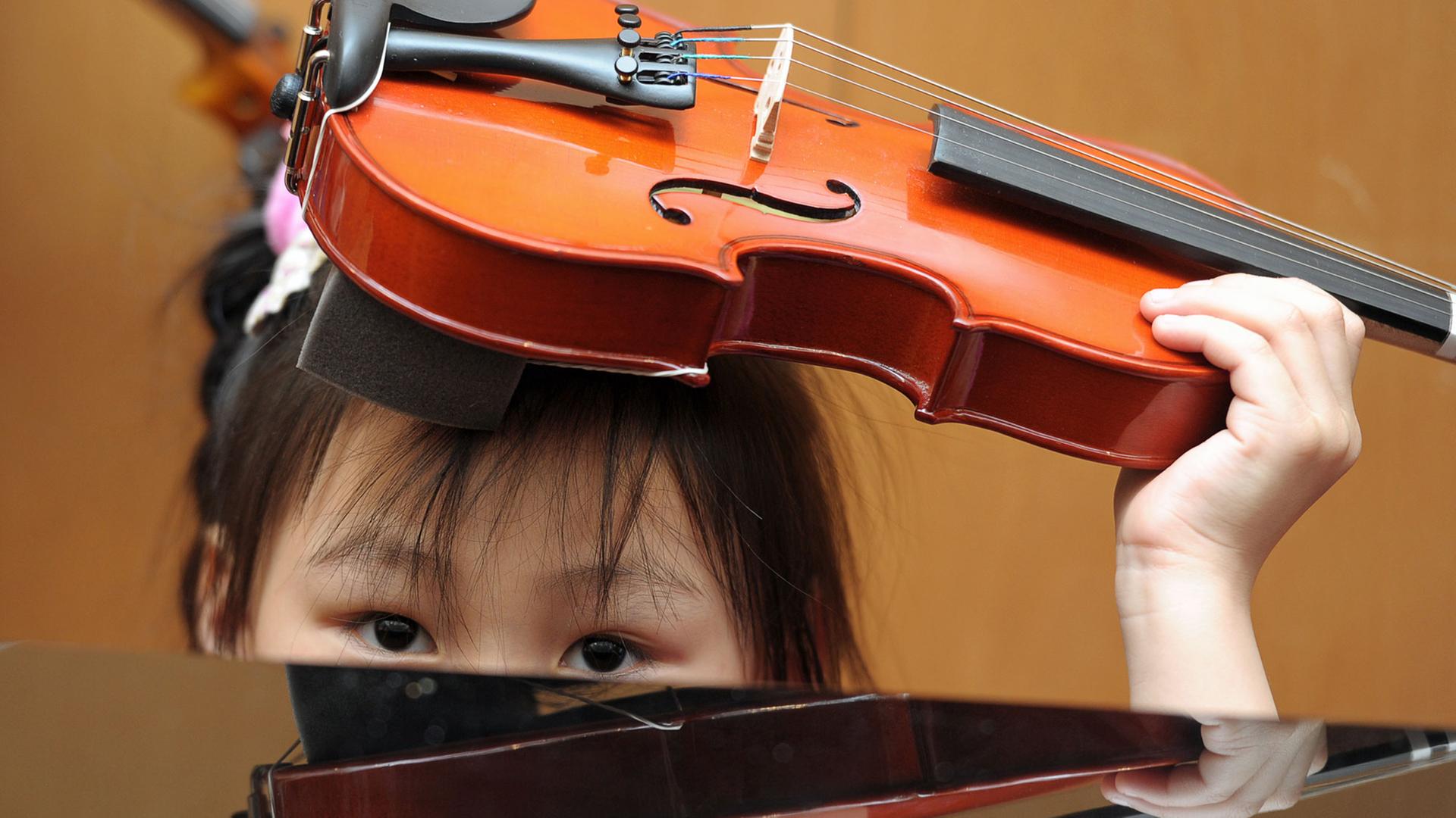 Die fünfjährige Emely lernt am Montag (13.02.2012) in der Musikschule der Hofer Symphoniker in Hof (Oberfranken) Geige zu spielen.