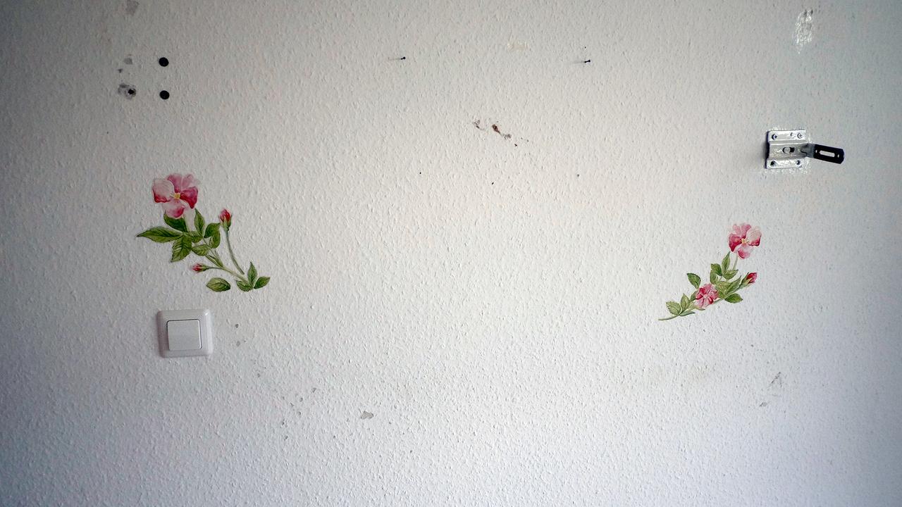 Blumenmuster und Bohrlöcher auf einer Tapete