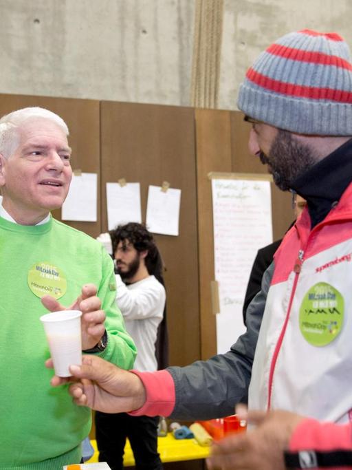 Der Präsident des Zentralrats der Juden, Schuster, verteilt im Rahmen des Mitzvah Day Essen an die Bewohner einer Flüchtlingsunterkunft in Berlin.