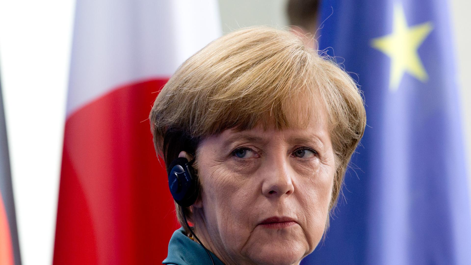 Bundeskanzlerin Angela Merkel vor Fahnen