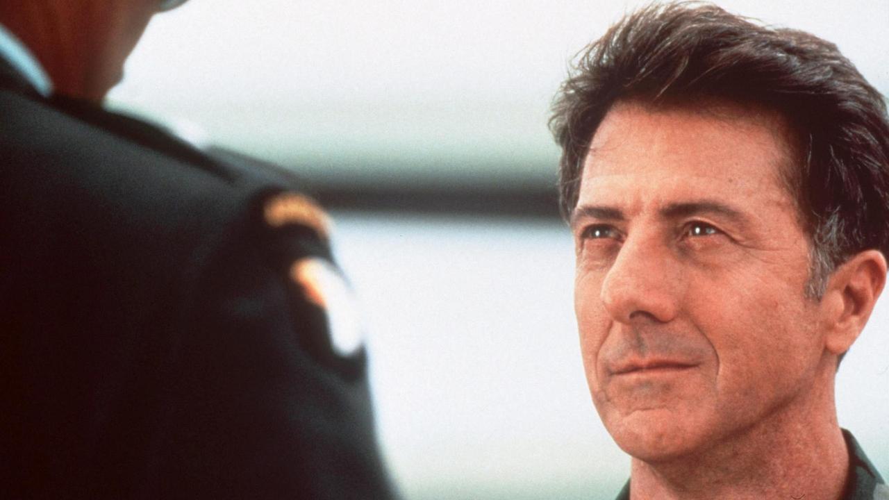 Szene aus dem Film "Outbreak: Lautlose Killer" mit dem Schauspieler Dustin Hoffman. Ein Mann steht vor einem Soldaten.