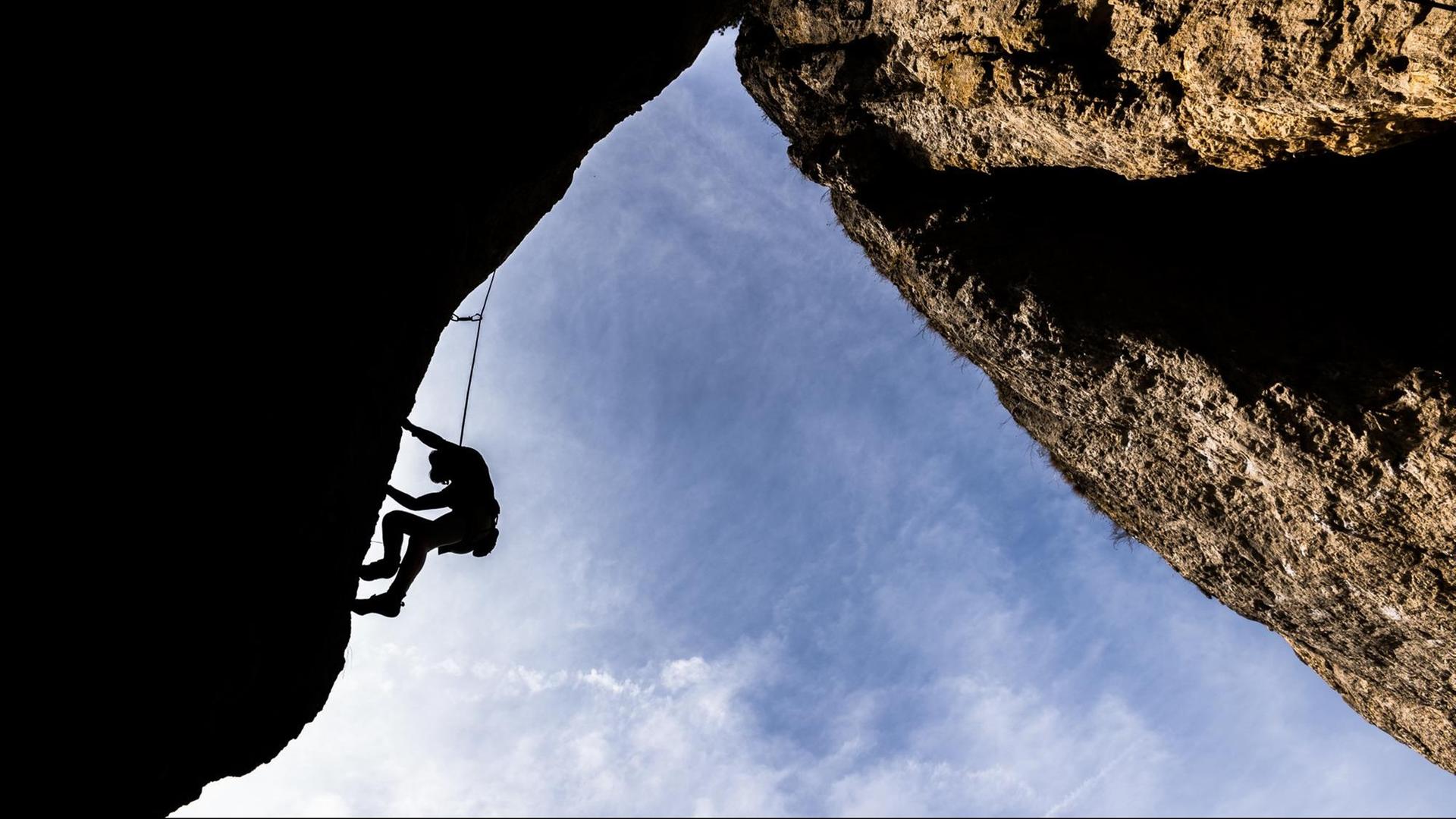 Sophie aus Erlangen klettert am 12.04.2015 bei Loch (Bayern) eine Felswand hinauf. Die Fränkische Schweiz ist ein wahrhaftes Kletter-Mekka. Die milden Temperaturen laden zu sportlichen Tagen ein. Foto: Nicolas Armer/dpa | Verwendung weltweit