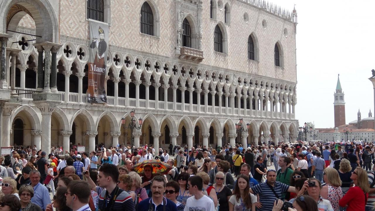 Touristen drängeln sich vor dem Dogenpalast in Venedig. Die Stadt hat die Anzahl der täglichen Schiffsanläufe mittlerweile reduziert, um dem Besucherandrang Herr zu werden.
