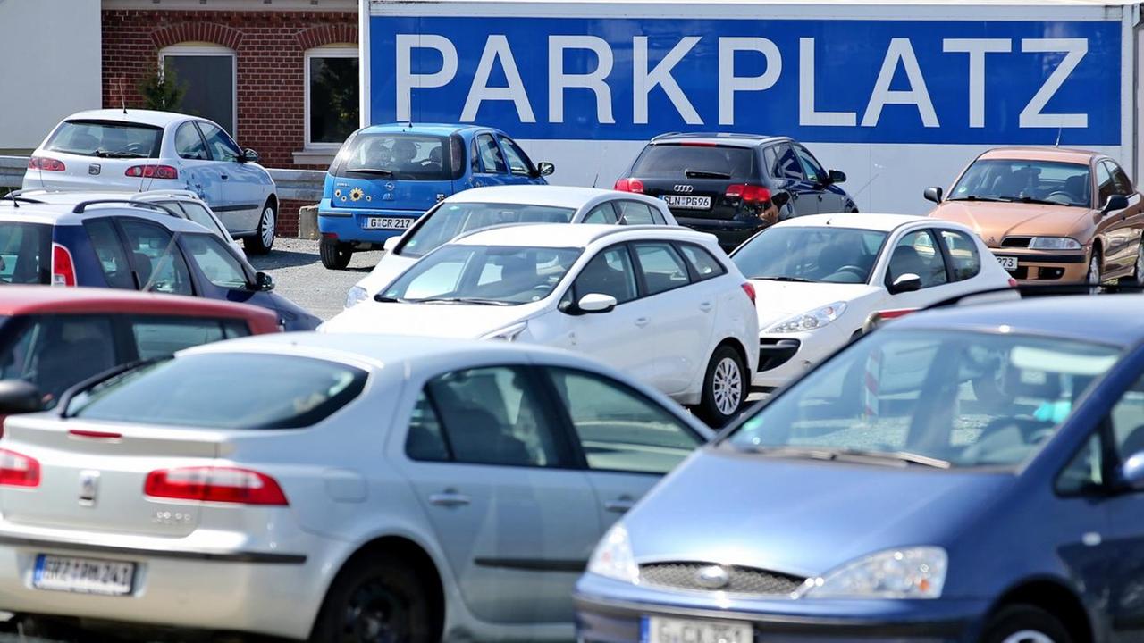 Ein überdimensionales Schild "Parkplatz" hängt am 29.04.2015 an einer Parkfläche für Pkw in Gera (Thüringen)