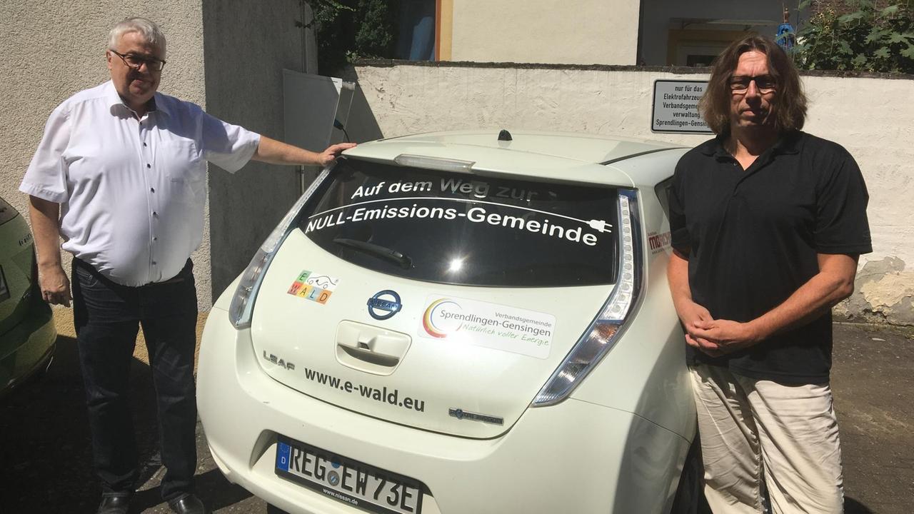 Bürgermeister Manfred Scherer und Energieberater Andreas Pfaff am Elektro-Mobil der Gemeindeverwaltung