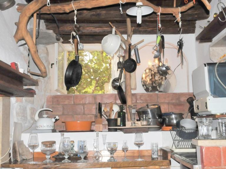 Diverse Küchengeräte hängen, stehen und liegen in der Küche des Künstlers Arsenije Jovanović