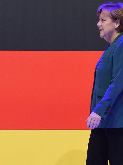 Bundeskanzlerin Angela Merkel vor einer Deutschlandfahne