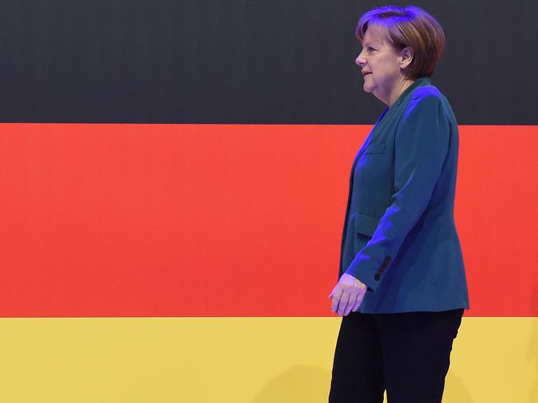 Bundeskanzlerin Angela Merkel vor einer Deutschlandfahne