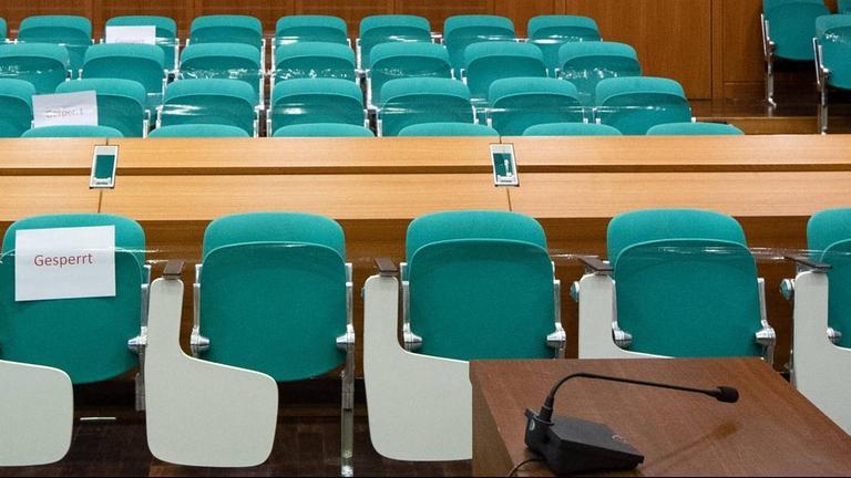 Gerichtsverhandlung im Zeichen der Corona Krise, nur sehr wenige Plätze stehen zur Verfügung, Reihen sind mit dem Hinweis "gesperrt" versehen, Sitze sind durch Folie nicht zugänglich gemacht. Frankfurt am Main, 25. März 2020.