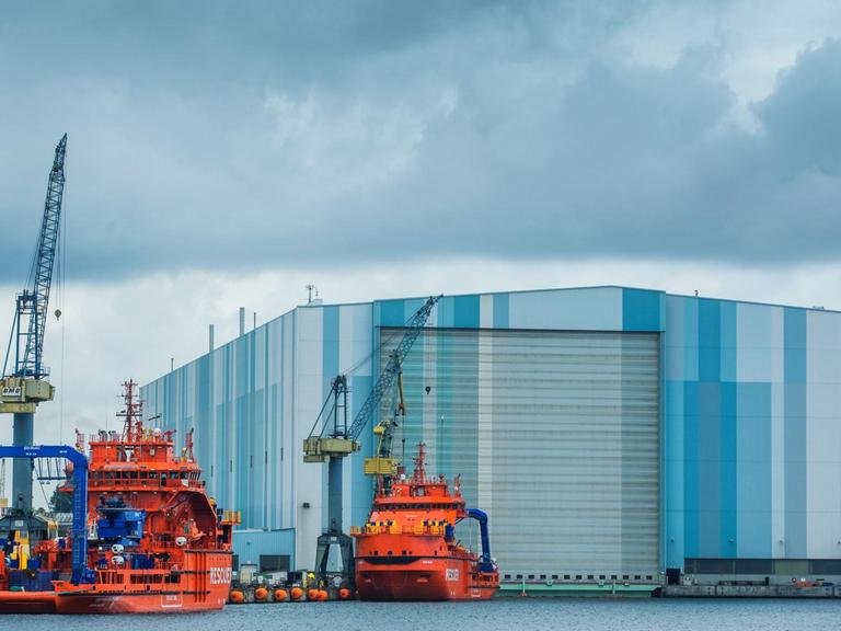 Dunkle Wolken ziehen am 09.06.2015 über die Schiffbauhalle der Nordic Yards Werft in Wismar (Mecklenburg-Vorpommern), vor der zwei eisbrechende Rettungs- und Bergungsschiffe in Ausrüstungskai liegen.