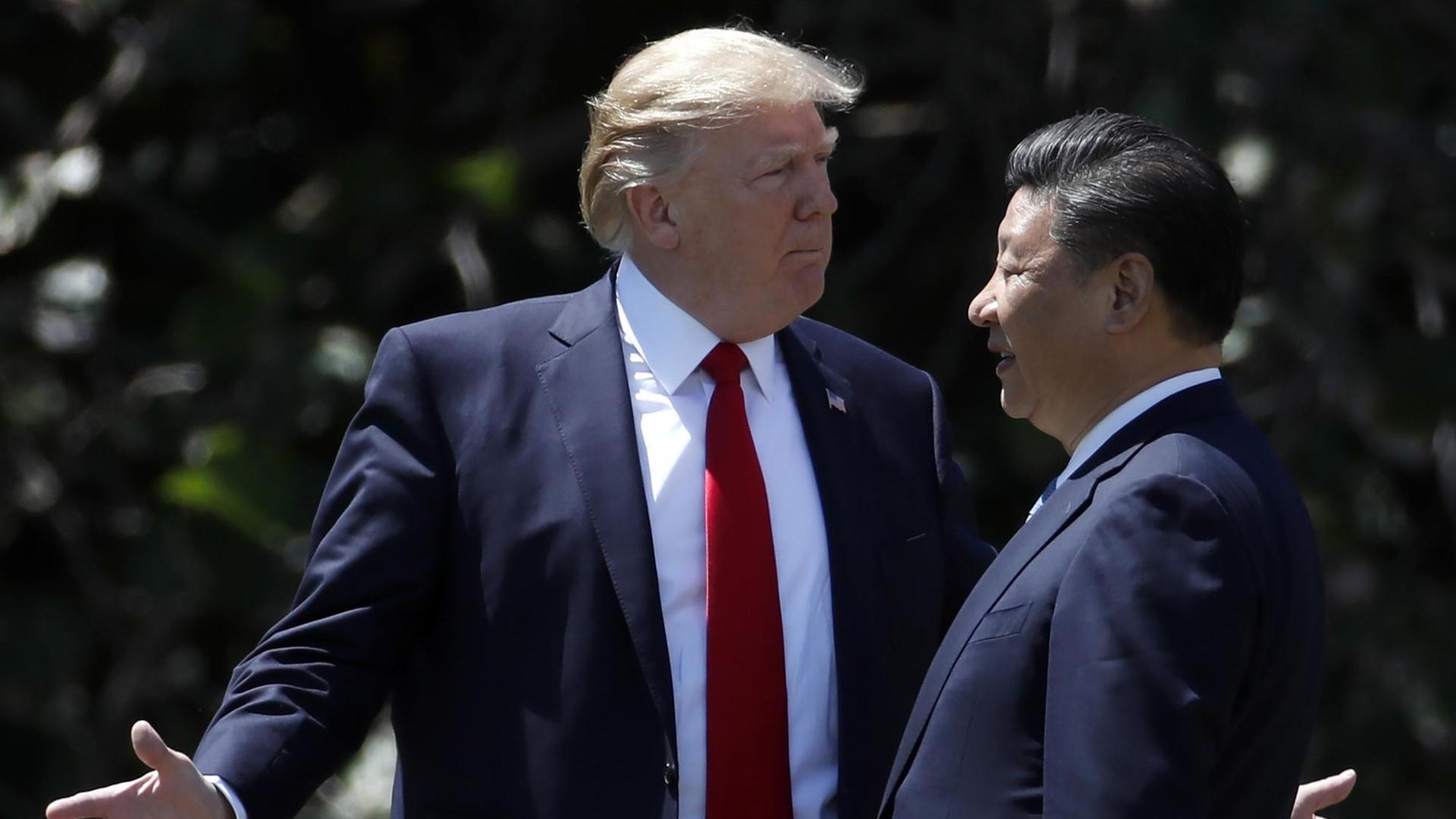 US-Präsident Trump und Chinas Staatspräsident Xi stehen nebeneinander. Trump macht eine ausladende Geste mit den Armen. US-Präsident Trump und Chinas Staatspräsident Xi stehen nebeneinander. Trump macht eine ausladende Geste mit den Armen.