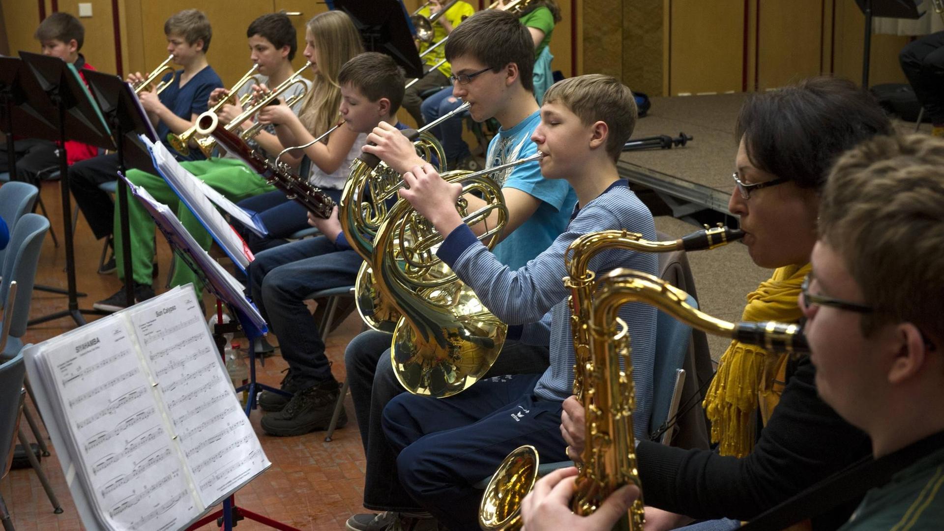 Schüler spielen im Schulorchester verschiedene Blasinstrumente