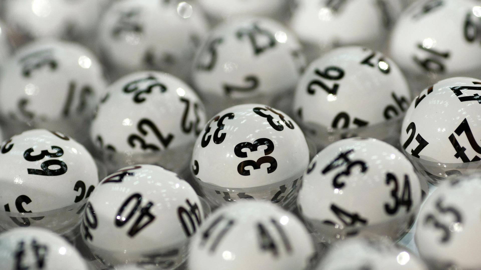 Lotto-Kugeln liegen nebeneinander im Gerät vor der Ziehung.