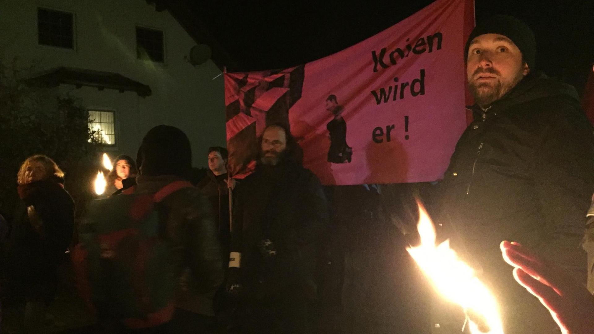 Mitglieder einer Antifa-Demo in Bornhagen halten ein Banner hoch auf dem "Knien wird er" geschrieben steht. Der Satz bezieht sich auf die Forderung der Stelen-Künstler, der AfD-Politiker Björn Höcke solle vor ihrer Holocaust-Nachbildung nieder knien.