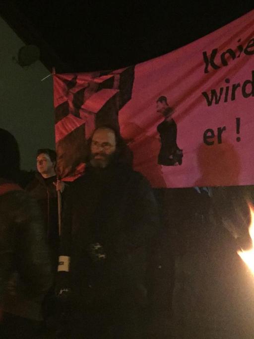 Mitglieder einer Antifa-Demo in Bornhagen halten ein Banner hoch auf dem "Knien wird er" geschrieben steht. Der Satz bezieht sich auf die Forderung der Stelen-Künstler, der AfD-Politiker Björn Höcke solle vor ihrer Holocaust-Nachbildung nieder knien.
