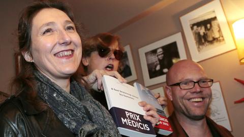 (L-R) French writer Marie Darrieussecq, awarded with the Medicis Prize for her book "Il faut beaucoup aimer les hommes" (P.O.L.), French writer and member of the Medicis Prize jury Anna Gavalda, and Dutch writer Toine Heijmans, awarded with the foreign Medicis Prize for his book "En mer" (Bourgois), pose together on November 12, 2013 in Paris. AFP PHOTO / JACQUES DEMARTHON / AFP PHOTO / JACQUES DEMARTHON