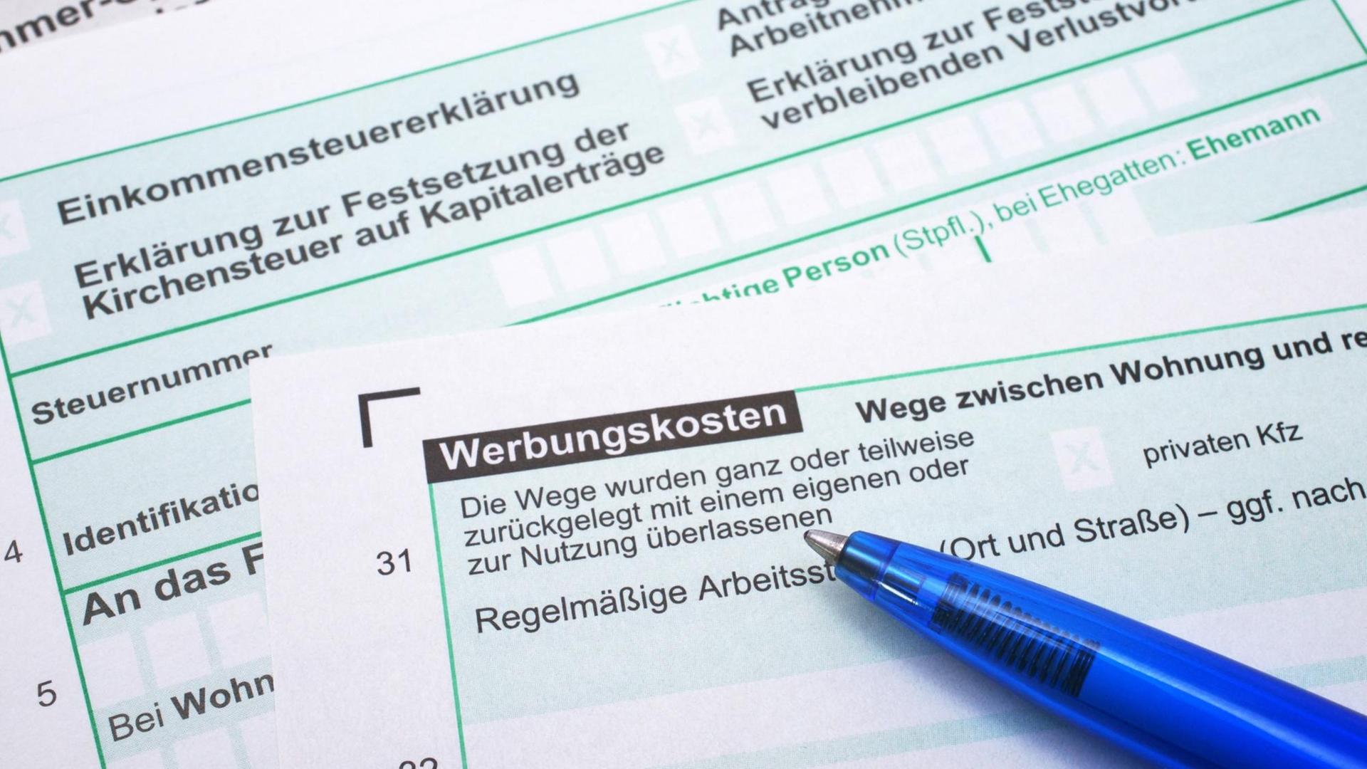 Auf dem Bogen für eine Steuerklärung liegt ein blauer Kugelschreiber.