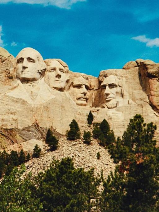 Ansicht des Mount Rushmore mit den vier in einen Felsen gehauenen Präsidentenköpfen.