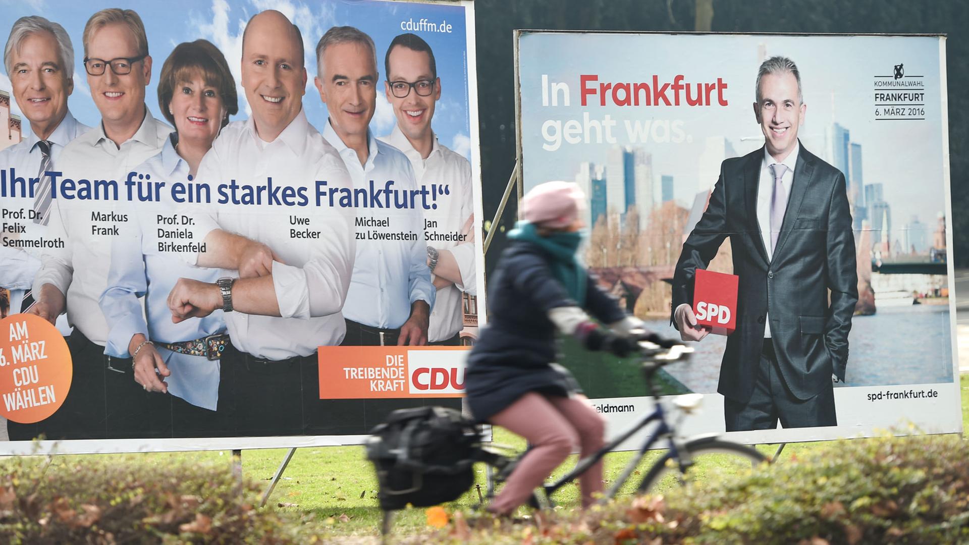 Eine Radfahrerin fährt am 18.02.2016 in Frankfurt am Main (Hessen) an Wahlplakaten von CDU (l) und SPD vorbei. 