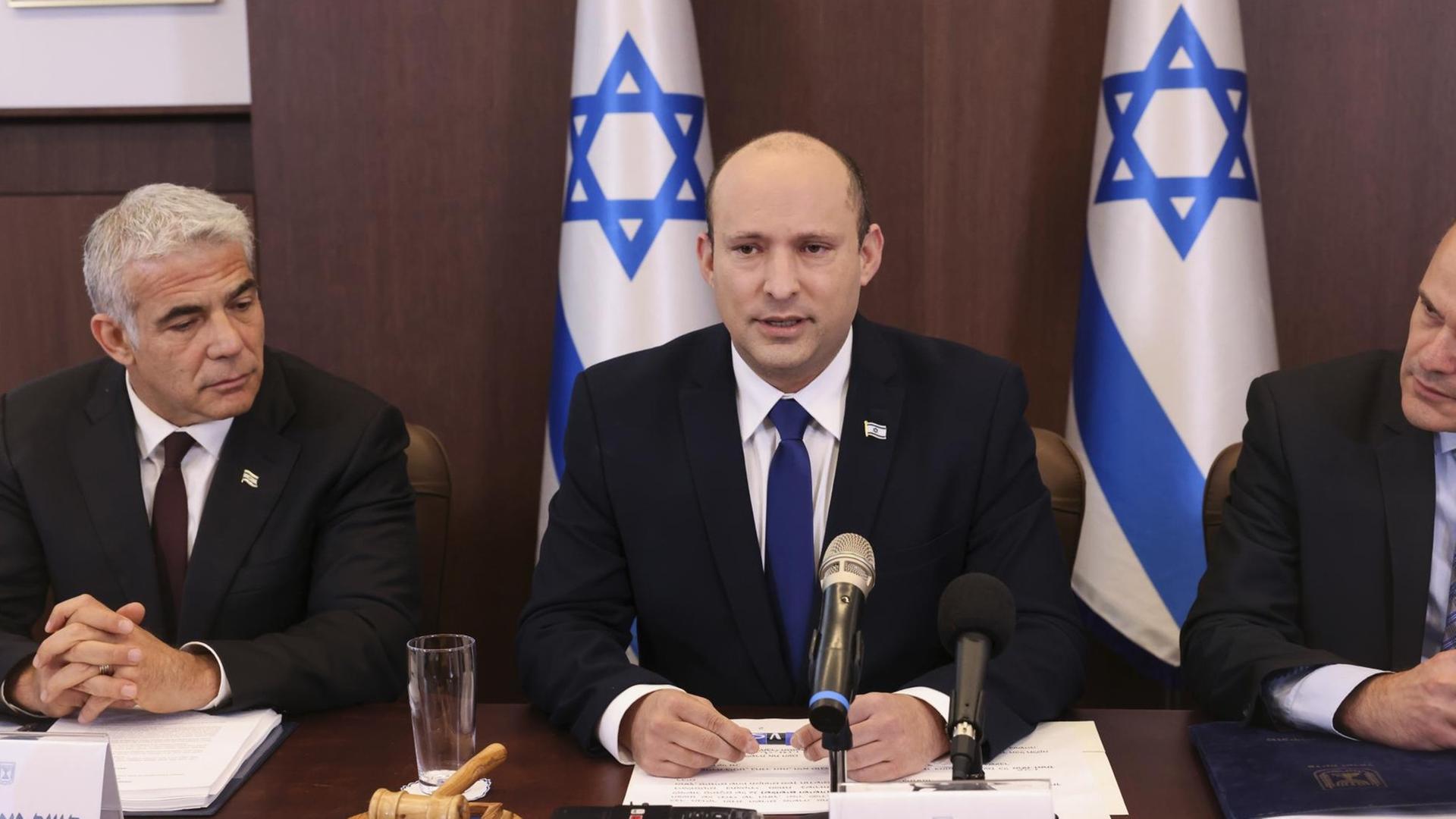Israels neuer Premierminister Naftali Bennett (m) neben Außenminister Yair Lapid (l) (Emmanuel Dunand/Pool Photo via AP)