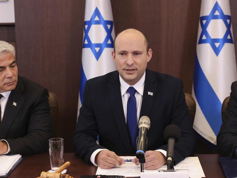 Israels neuer Premierminister Naftali Bennett (m) neben Außenminister Yair Lapid (l) (Emmanuel Dunand/Pool Photo via AP)