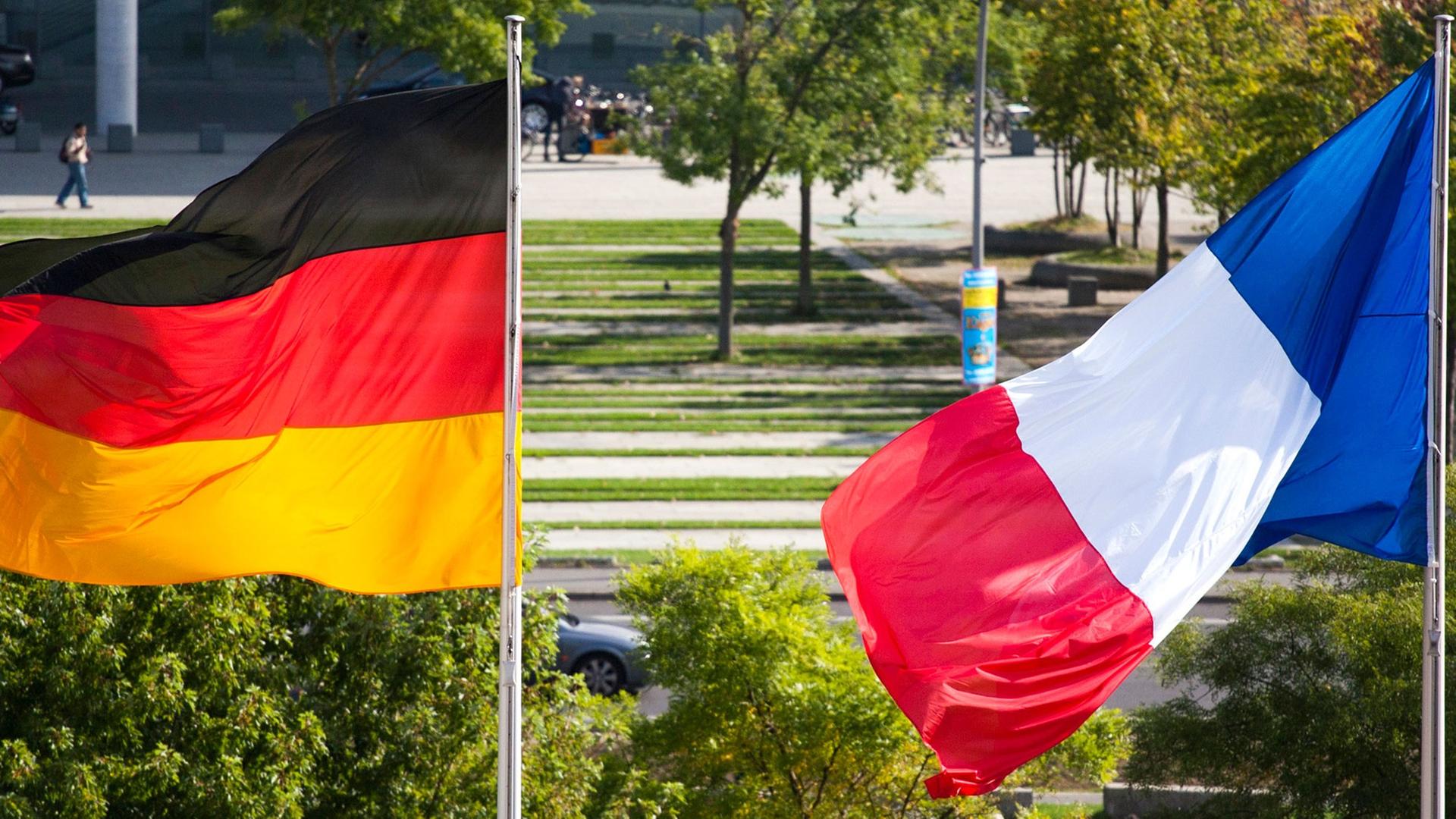 Die deutsche und die französische Nationalflagge wehen aus Anlass des Besuches von Frankreichs Regierungschef Manuel Valls vor dem Bundeskanzleramt in Berlin am 22.09.14.