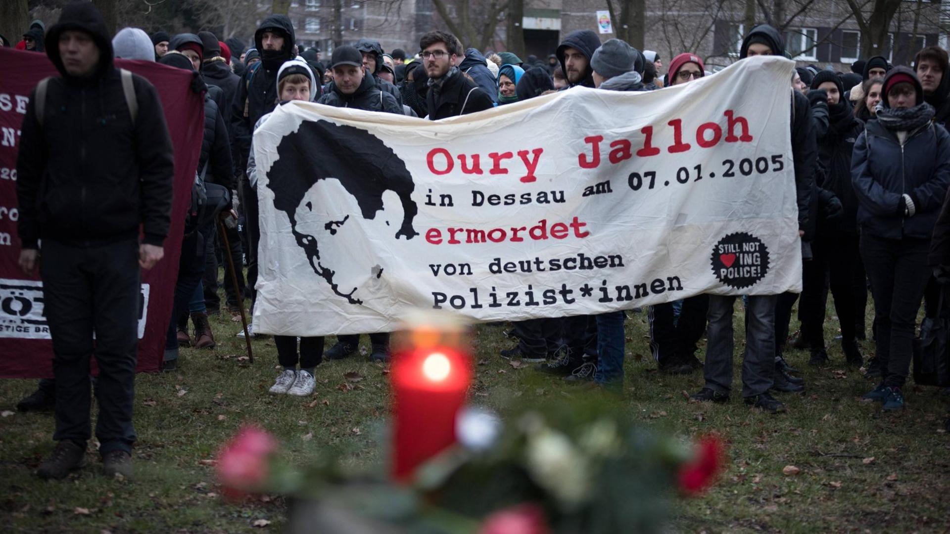 Demonstrierende halten ein Banner, auf dem steht: Oury Jalloh in Dessau am 07.01.2005 ermordet von deutschen Polizist*innen.