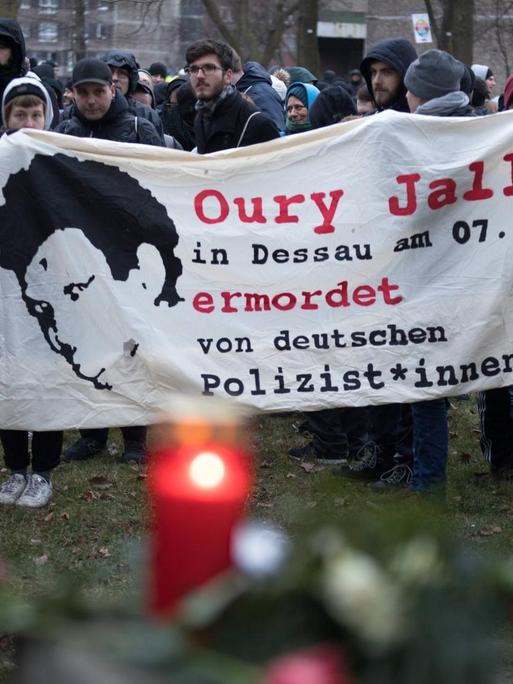 Demonstrierende halten ein Banner, auf dem steht: Oury Jalloh in Dessau am 07.01.2005 ermordet von deutschen Polizist*innen.