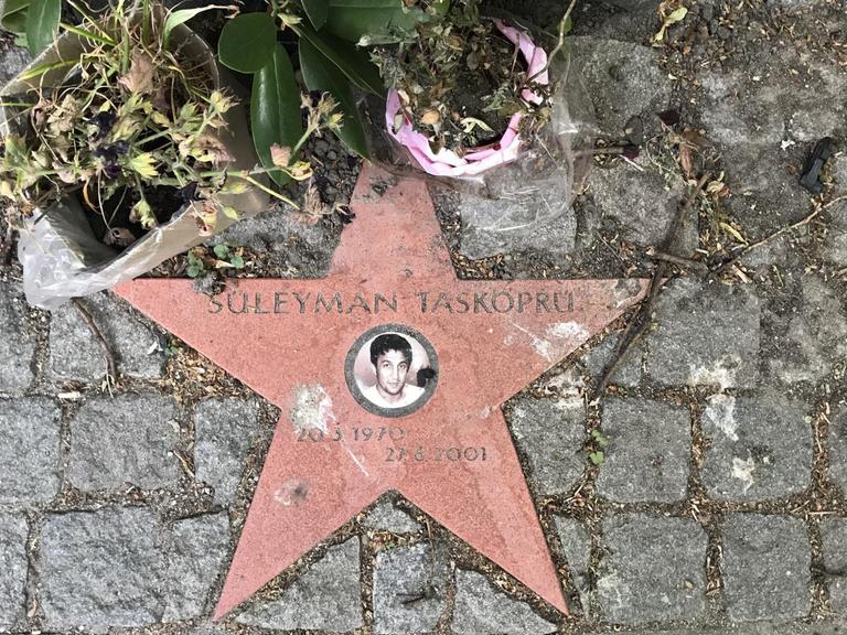 In der Hamburger Schützenstraße erinnert neben einem Gedenkstein auch ein Stern mit einem kleinen Porträtfoto an den Gemüsehändler Süleyman Tasköprü, der hier von den Rechtsterroristen des NSU erschossen wurde