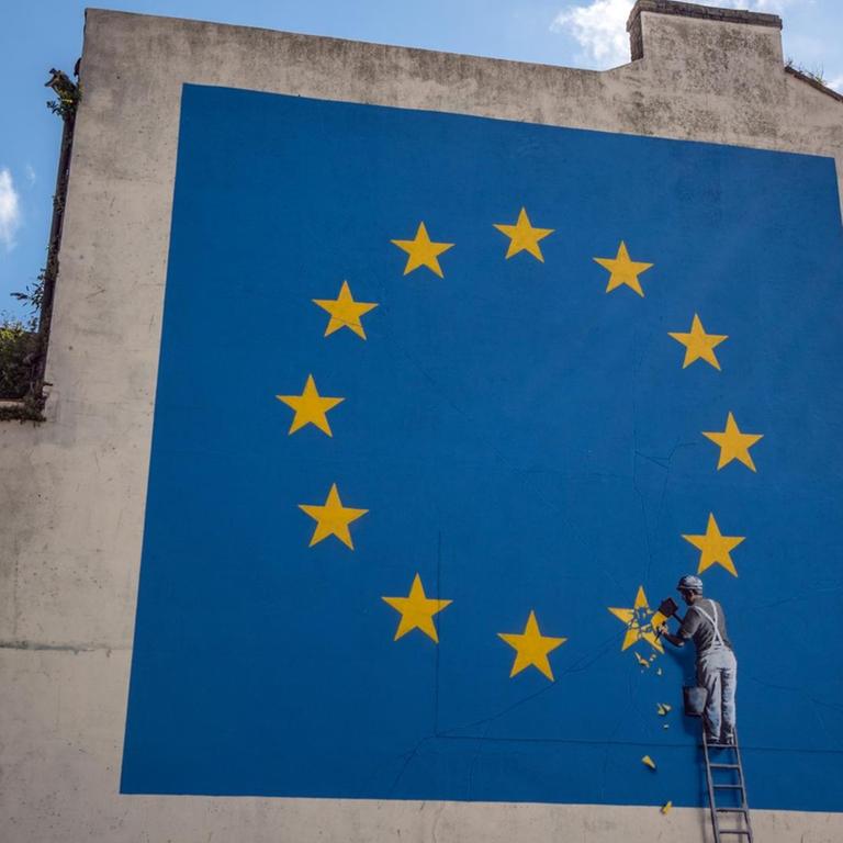 Banksy Street-Art: Jemand entfernt einen Stern aus der Europaflagge an einem Haus
