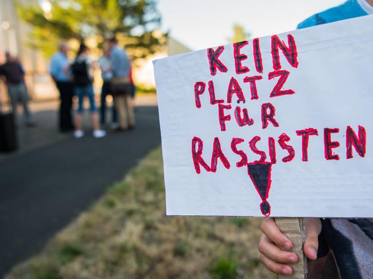 Ein Junge hält bei der Mahnwache in Wächtersbach ein Schild mit der Aufschrift "Kein Platz für Rassismus".