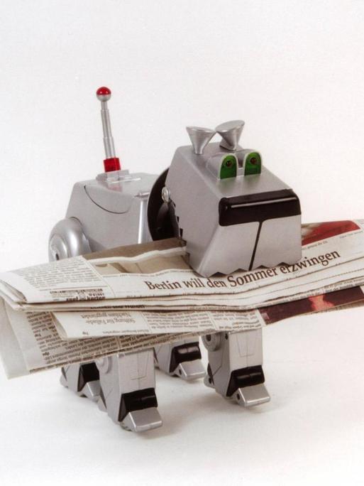 Roboterhund mit aufgerollter Zeitung in der Schnauze
