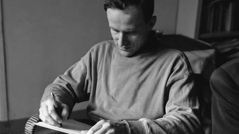Der französische Schriftsteller Boris Vian sitzt in seiner Pariser Wohnung und schreibt auf ein Blatt Papier