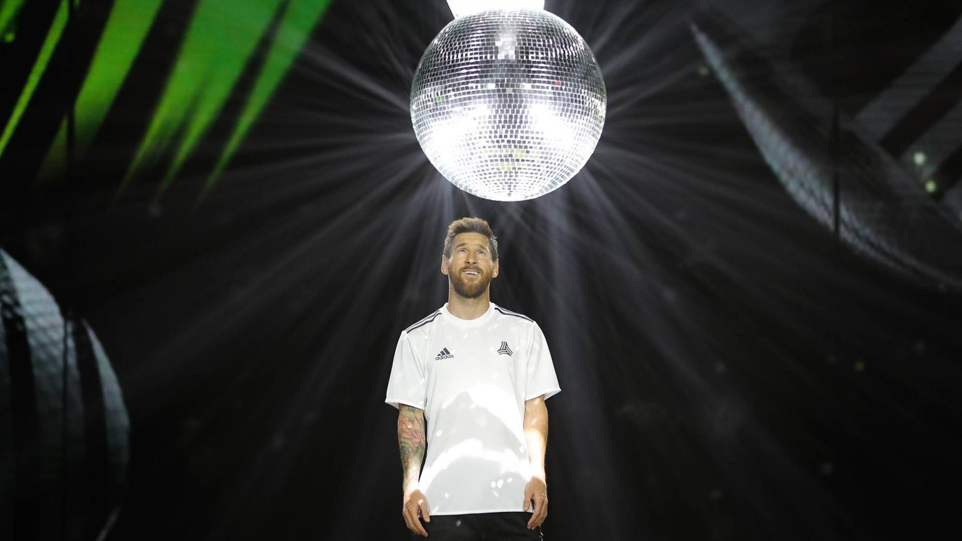 Der argentinische Fußballer Lionel Messi ist Werbefigur für den Sportartikelhersteller adidas. Hier zu sehen mit einer großen Diskokugel.