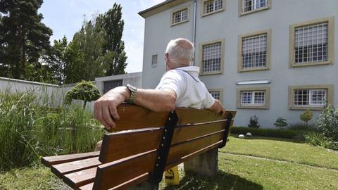 Ein älterer Häftling sitzt vor dem Gefängnisgebäude in Singen (Baden-Württemberg)