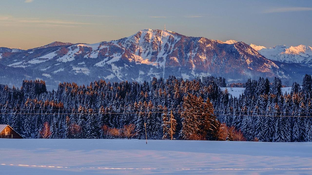 Abendsonne taucht den Gipfel des Grünten (1737 m) der Allgäuer Berge in warmes Licht, an einem Winterabend bei Missen, Bayern, Deutschland.