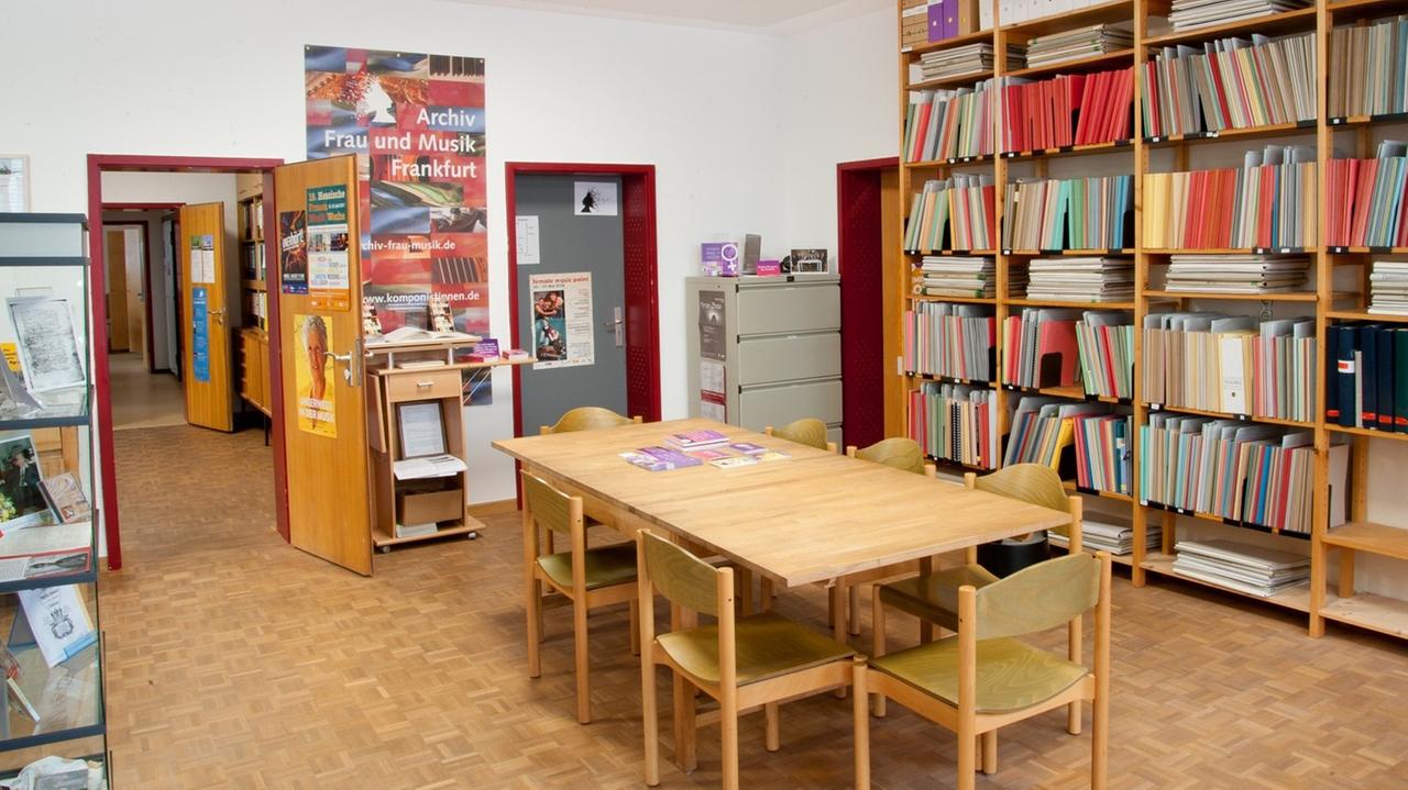 Ein Archivraum mit Lesetisch und Regalen, eine offene Tür führt auf den Flur.