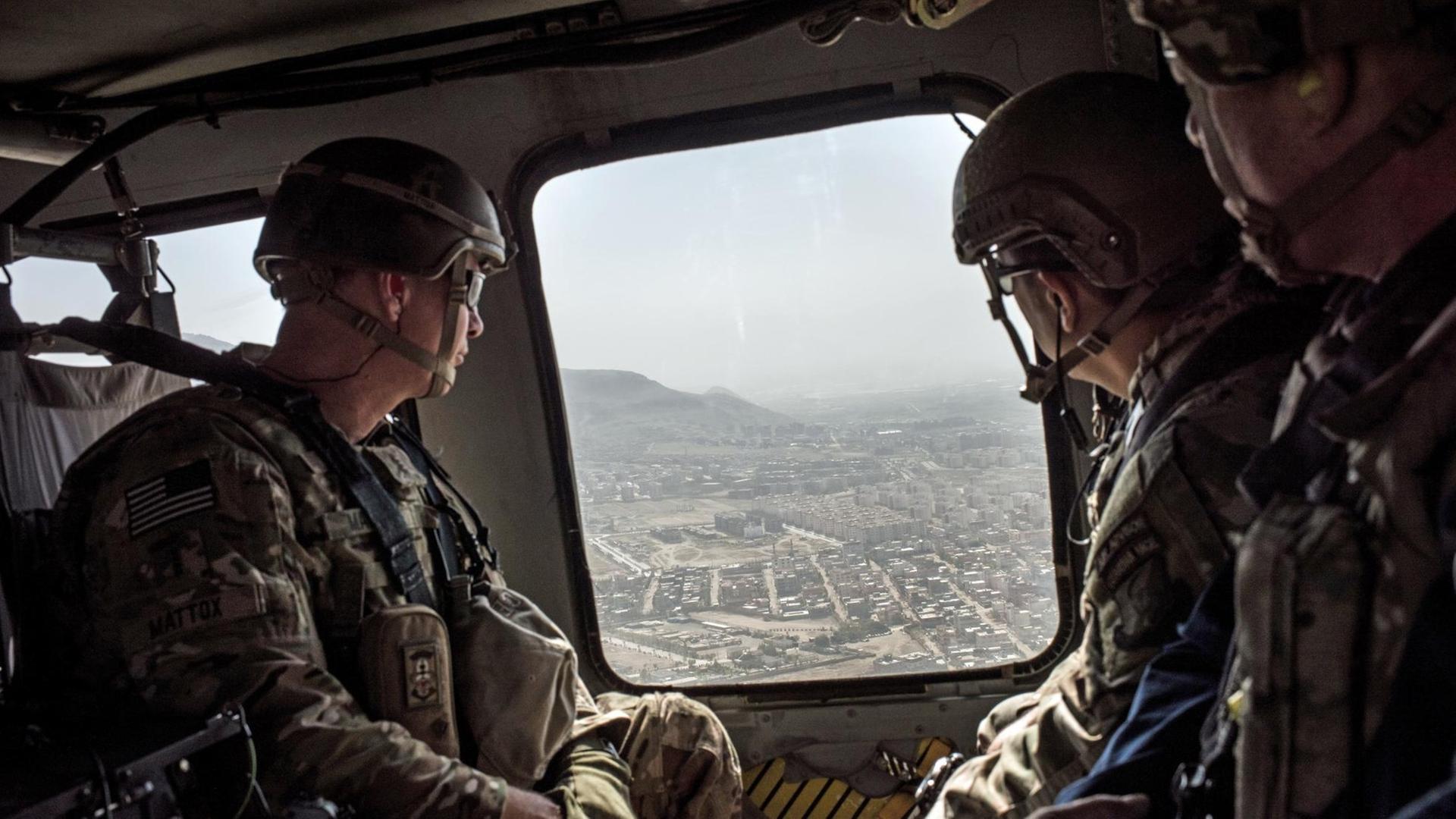 Amerikanische Soldaten schauen aus einem Helikopter auf Afghanistans Hauptstadt Kabul herunter