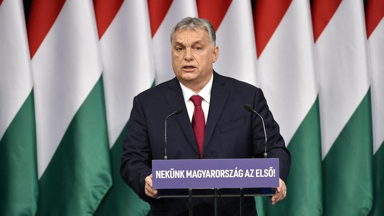 Viktor Orban, Ministerpräsident von Ungarn, steht an einem Rednerpult. Im Hintergrund mehrere ungarische Flaggen.