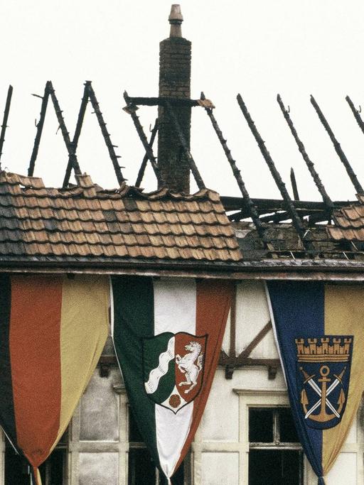 Die Fahnen der Bundesrepublik Deutschland, der Türkei, Solingens und Nordrhein-Westfalens hängen zur Trauerfeier vor dem ausgebrannten Haus der türkischen Familie Genc in Solingen.