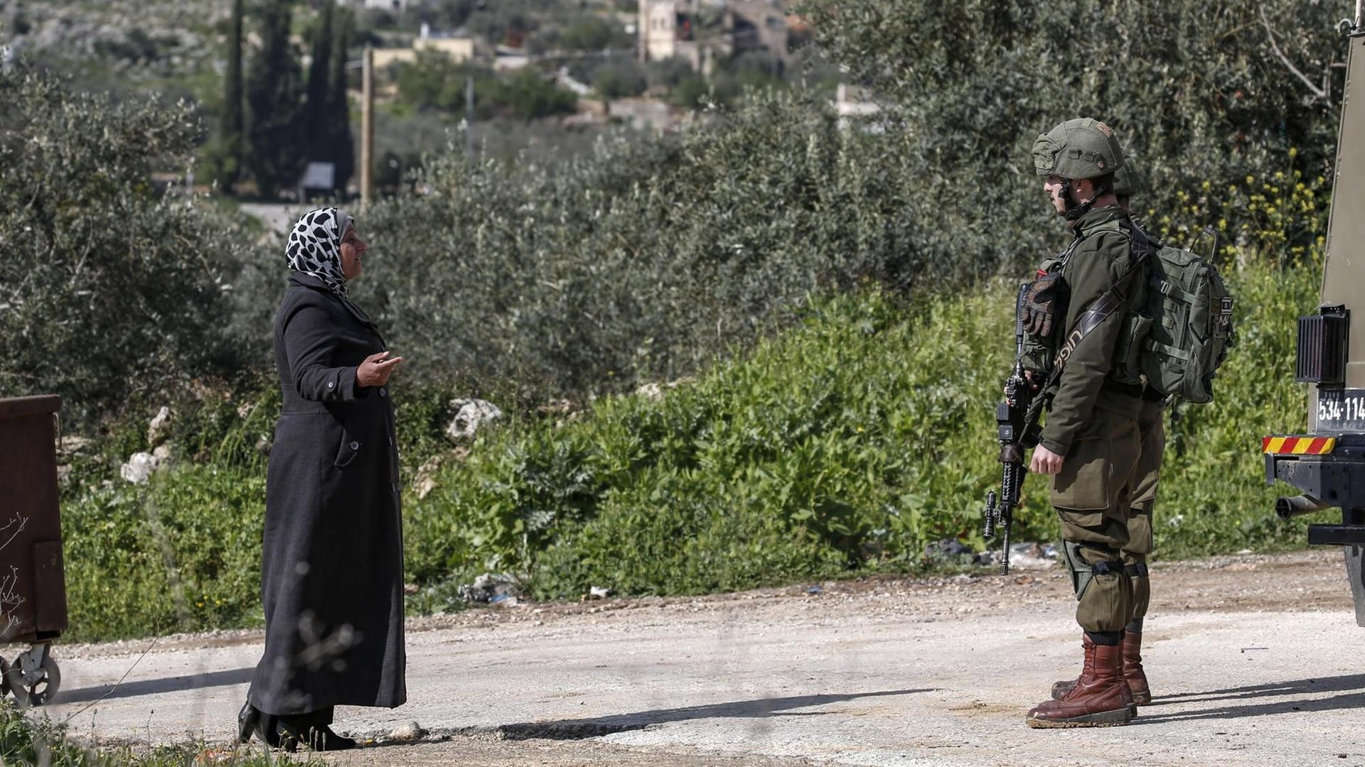 In der Nähe der jüdischen Siedlung Ariel im Westjordanland spricht eine Palästinenserin mit einem israelischen Soldaten
