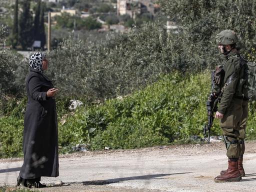 In der Nähe der jüdischen Siedlung Ariel im Westjordanland spricht eine Palästinenserin mit einem israelischen Soldaten