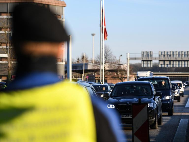 Ein Beamter der schweizerischen Grenzwache steht am Grenzübergang an der A5. In der Coronavirus-Krise führt Deutschland am Montag umfassende Kontrollen und Einreiseverbote auch an den Grenzen auch zur Schweiz ein.