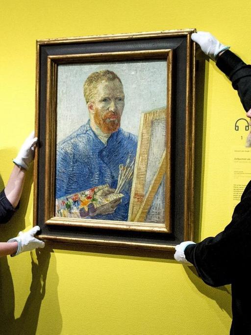 Zwei Mitarbeiter hängen van Goghs "Selbstbildnis vor der Staffelei" auf nachdem das Museum in Amsterdam umgebaut wurde.